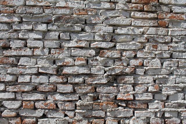 Oude baksteenmuur met een verweerde witte laag